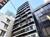 コンフォリア・リヴ茅場町 街中に建つモダンな外観の建物を下から見上げた様子