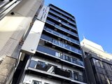 コンフォリア・リヴ茅場町 青空を背景に見上げた、モダンなバルコニー付きの建物外観
