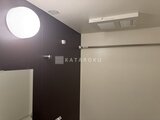コンフォリア・リヴ茅場町 濃紫色のアクセントパネルと白い円形照明が特徴的なバスルーム