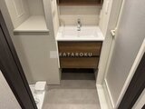 コンフォリア・リヴ茅場町 木目調の洗面台と収納が備わった清潔感のある洗面スペース