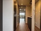 コンフォリア・リヴ茅場町 木目調フローリングと濃いブラウン建具でまとめた廊下