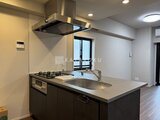 コンフォリア・リヴ茅場町 黒を基調とした対面キッチンと窓からの採光が印象的な空間