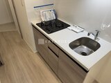 プライムブリス本所吾妻橋 白いワークトップとグレーの扉が組み合わさったキッチン