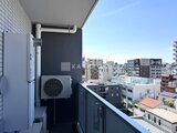 プライムブリス本所吾妻橋 バルコニーに設置されたエアコン室外機と都市風景が見える眺望