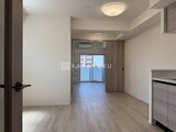 プライムブリス本所吾妻橋 明るい照明の落ち着いた雰囲気の廊下から見たリビングダイニング