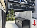 リージア代々木ビナリオ モダンなデザインの建物エントランス前に配置されたゴミ置き場