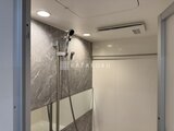 リージア代々木ビナリオ グレーの石目調タイルと白いパネルを組み合わせた浴室