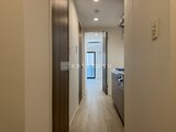 リージア代々木ビナリオ 廊下から見たキッチンと玄関への動線が明るく整理された空間