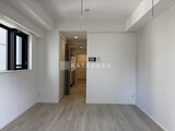 リージア代々木ビナリオ 白を基調とした開放的なリビングダイニングと奥のキッチンの様子