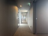 ディームス中野富士見町 廊下奥に向かって照明が明るく続く共用通路