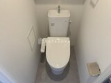 ディームス中野富士見町 温白色の壁と濃いめの床材でまとめた清潔感のあるトイレ空間