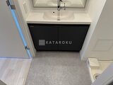 ディームス中野富士見町 黒いキャビネットと白いカウンタートップの洗面台