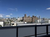 ディームス中野富士見町 高層階から望む都市風景と晴れた空が広がるバルコニー