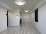 ディームス中野富士見町 明るい照明と落ち着いた木目床のリビングダイニング空間