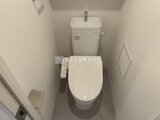 ディームス中野富士見町 温白色の壁に囲まれたシンプルな洋式トイレと便座