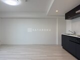ディームス中野富士見町 黒いキッチン設備とゆとりのあるリビングダイニング空間