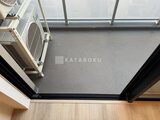 デュオフラッツ大森イースト ゆとりのあるバルコニー、グレー色の床材と開放的な天井の様子
