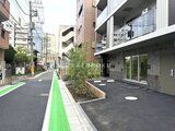 コンフォリア・リヴ文京千駄木 緑の帯状ラインが引かれたモダンな建物エントランスと周辺街並み