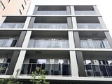 コンフォリア・リヴ文京千駄木 モダンな外観で縦ラインが特徴的な建物の正面イメージ