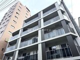 コンフォリア・リヴ文京千駄木 モダンなデザインの建物外観、白と濃いグレーの配色が印象的