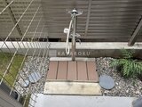 コンフォリア・リヴ文京千駄木 自転車置場とウッドデッキ、植栽が備わった共用部の様子