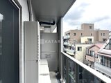 コンフォリア・リヴ文京千駄木 バルコニーに設置された室外機と周辺建物が見える眺め