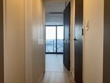 パークアクシス五反田スカイタワー 廊下から見た大きな窓と開放的な居住空間へのアクセス