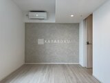 パークアクシス五反田スカイタワー 落ち着いた色合いのアクセントウォールと木目床の居室空間