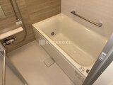 パークアクシス五反田スカイタワー 木目調パネルの落ち着いた浴室に、白い浴槽が設置された様子