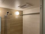 パークアクシス五反田スカイタワー 木目調タイルと円形照明で落ち着いた浴室の様子