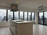 パークアクシス五反田スカイタワー 開放的な窓から都市風景を望むアイランドキッチン付きリビング