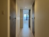パークアクシス五反田スカイタワー 奥行きのある廊下から景色が見える玄関方向を望む