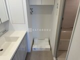 パークアクシス五反田スカイタワー 洗面台と洗濯機が配置された明るい洗面脱衣室