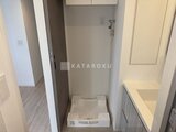 パークアクシス五反田スカイタワー 洗濯機置き場と洗面台を備えたシンプルなユーティリティスペース