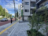 ザ・レジデンス・オブ・トーキョーN15 前面道路から見た建物エントランスと周辺の開放的な街並みの様子