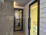 ザ・トリアス錦糸町 モダンなタイル張りの共用廊下と黒枠の玄関ドア