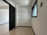 エルファーロ目黒3 明るい窓から光が入る廊下空間と黒いドア付きの洋室