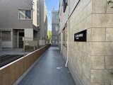 ウェルスクエア幡ヶ谷 建物間の通路から見たモダンな外観と整備された敷地の様子