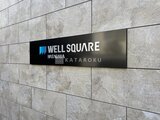 ウェルスクエア幡ヶ谷 グレータイルの外壁に設置されたモダンな建物サイン
