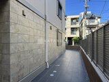 ウェルスクエア幡ヶ谷 モダンな外壁と整備された通路が広がる建物の側面