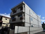 ウェルスクエア幡ヶ谷 青空を背景にした3階建てのモダンな建物外観