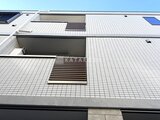 ウェルスクエア幡ヶ谷 モダンなタイル張りの建物外観とエントランス階段