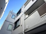 ウェルスクエア幡ヶ谷 モダンなタイル張りの建物外観と青空のコントラスト