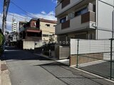 ウェルスクエア幡ヶ谷 前面道路から見た建物外観と駐車スペース
