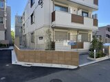 ウェルスクエア幡ヶ谷 木調フェンスと白いタイル貼りの落ち着いた印象の建物外観