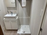 ウェルスクエア幡ヶ谷 白い洗面台と洗濯機パン付きの明るい洗面脱衣室