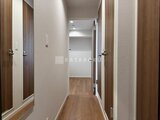 ウェルスクエア幡ヶ谷 木目調ドアが並ぶ廊下から奥の居室へ続く開放的な空間