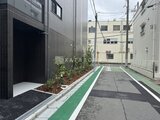 スタイリオ東品川 黒タイルと緑のラインが印象的な駐車場出入口