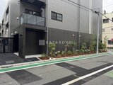 スタイリオ東品川 前面道路から見たモダンな建物外観と植栽のある入口
