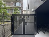 スタイリオ東品川 モダンなデザインの黒いゲートと駐輪スペースのある共用部分